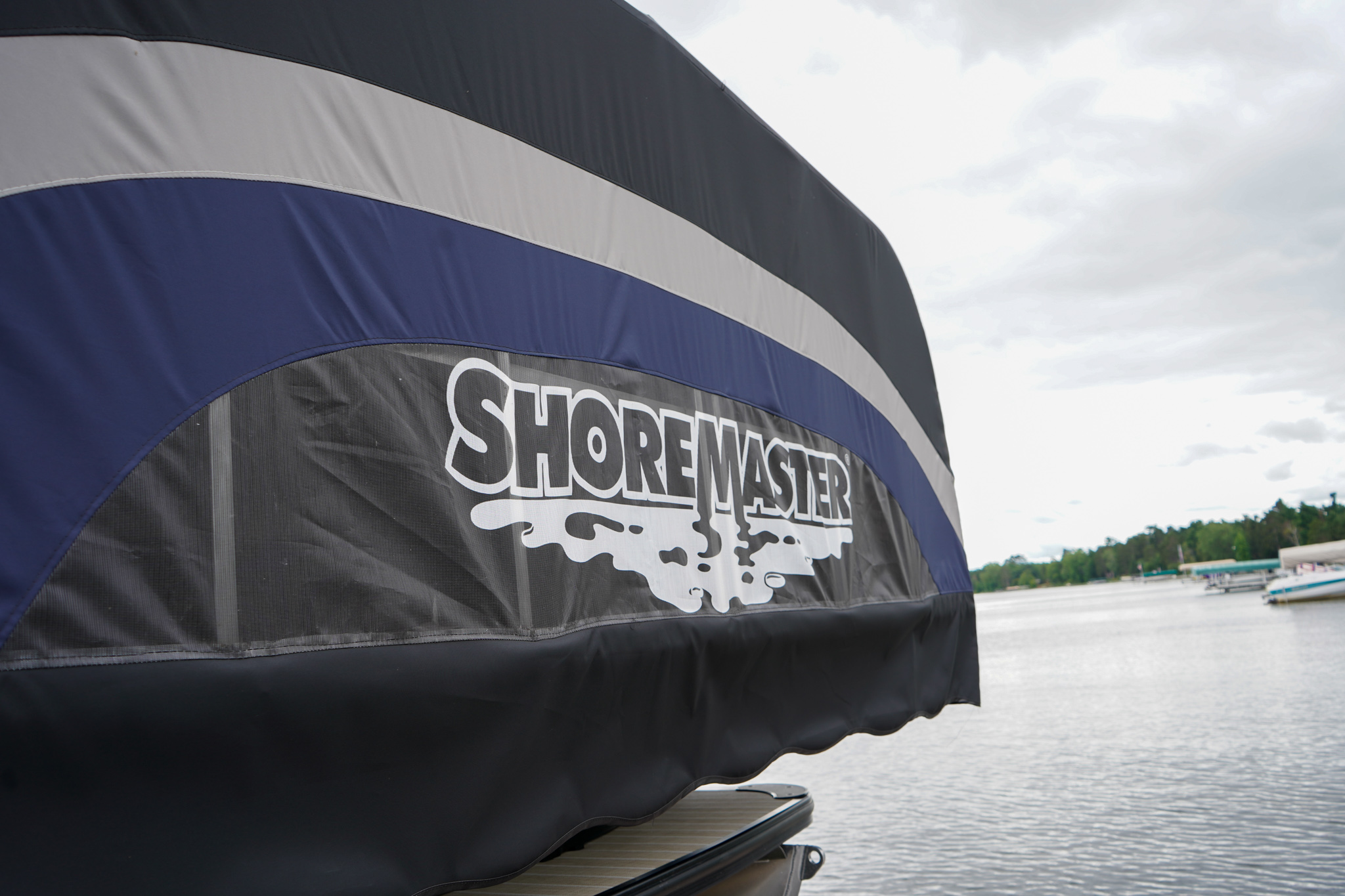 ShoreMaster boat canopy cover on a dock overlooking a lake.